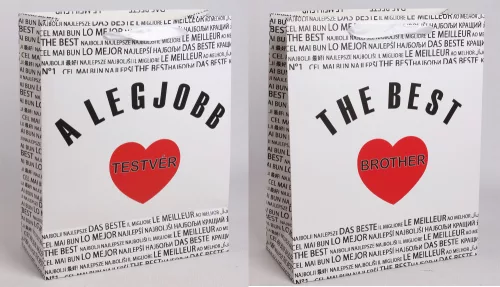 PAPÍRTASAK MATT, SZALAG FÜLLEL, FEHÉR ALAPON FEKETE NEMZETKÖZI ÍRÁSSAL A HÁTTÉRBEN, A LEGJOBB TESTVÉR/ THE BEST BROTHER FELIRATTAL, PIROS SZÍVVEL